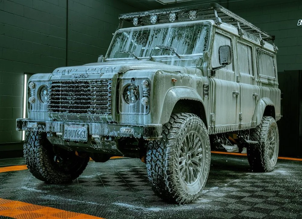 Land Rover Defender covered in snow foam during a decontamination wash at Artec Automotive