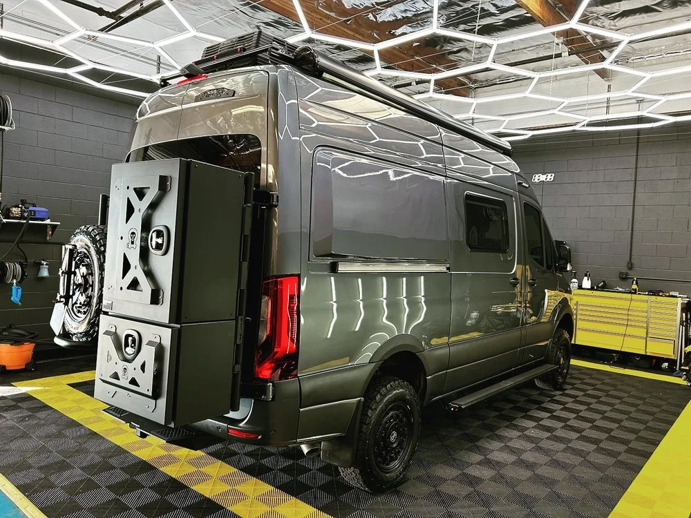 Rear of an olive green Mercedes-Benz Sprinter overland conversion with external storage