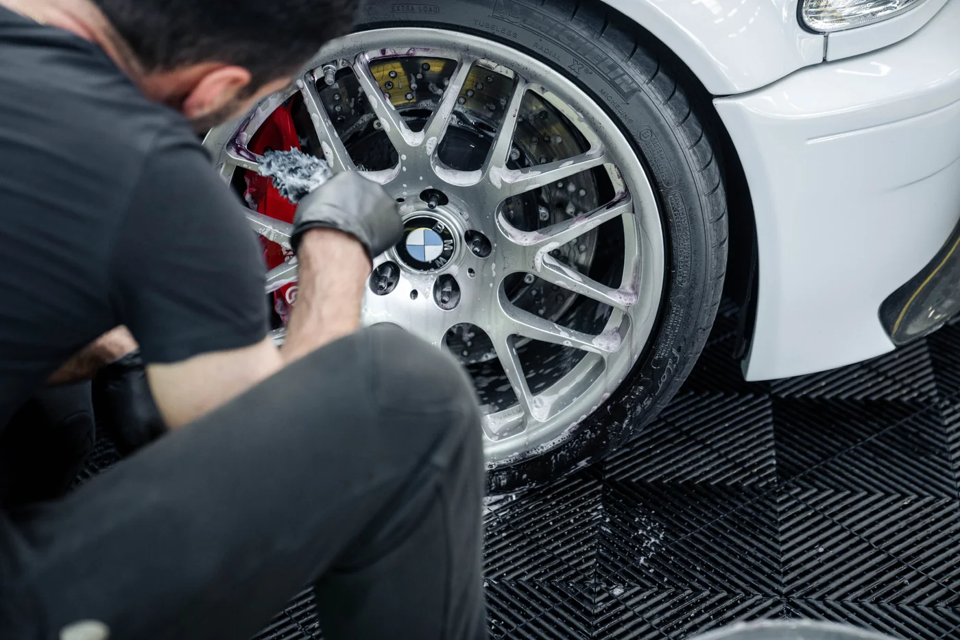 Technician fitting a BBS wheel to a BMW M3 in the workshop