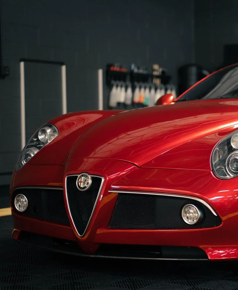 Front view of a red Alfa Romeo 8C Competizione in the Artec Automotive workshop