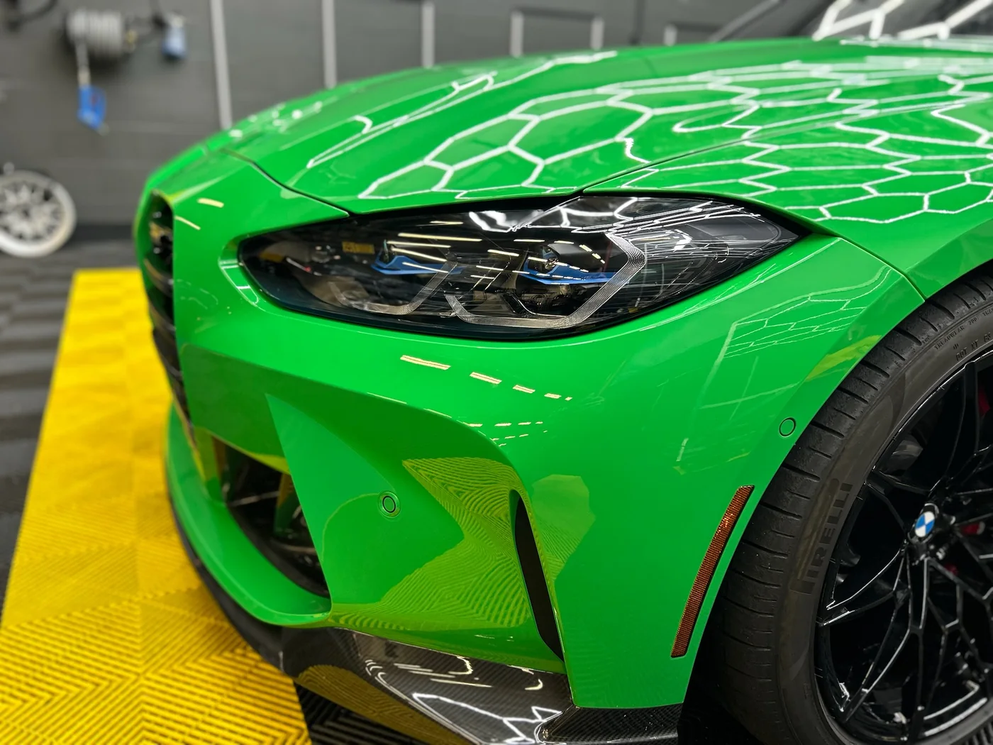 Green BMW M4 with paint protection film being applied to the front bumper at Artec Automotive