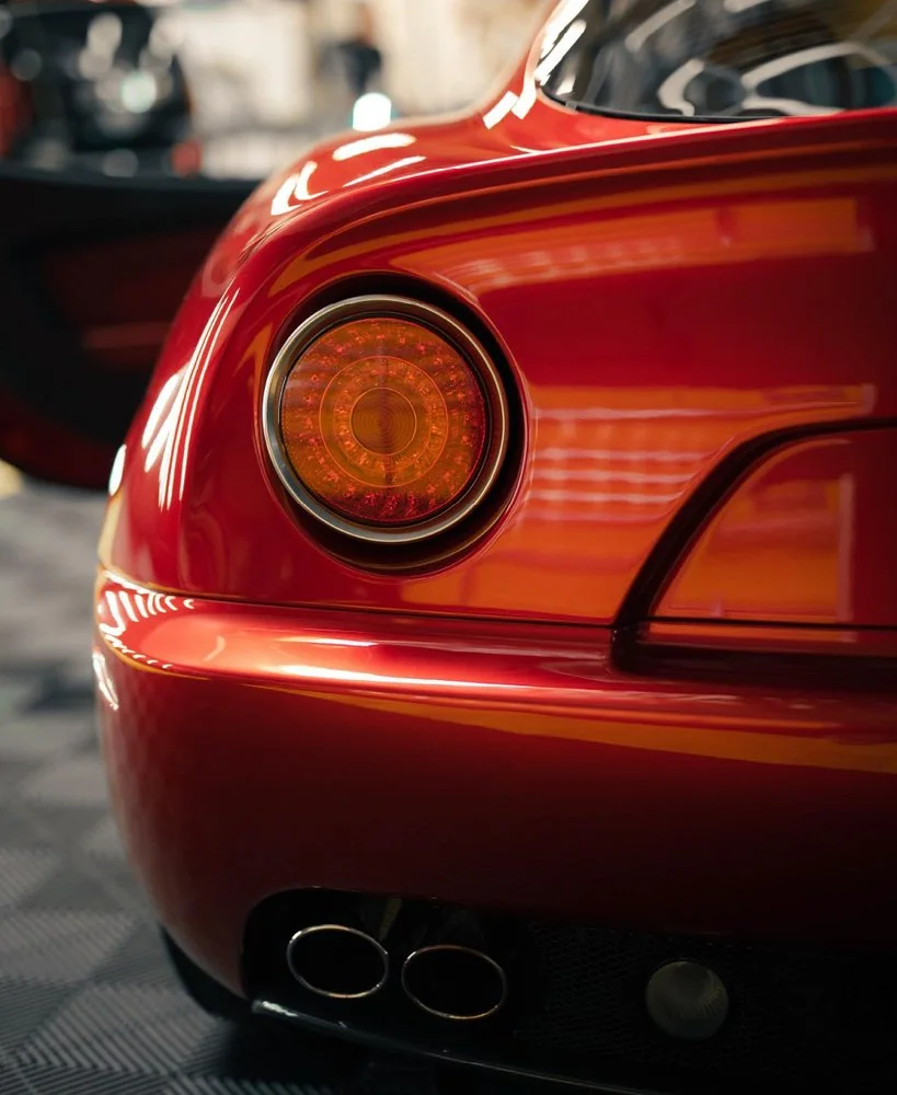 Close-up of a red sports car tail light showing paint gloss after ceramic coating
