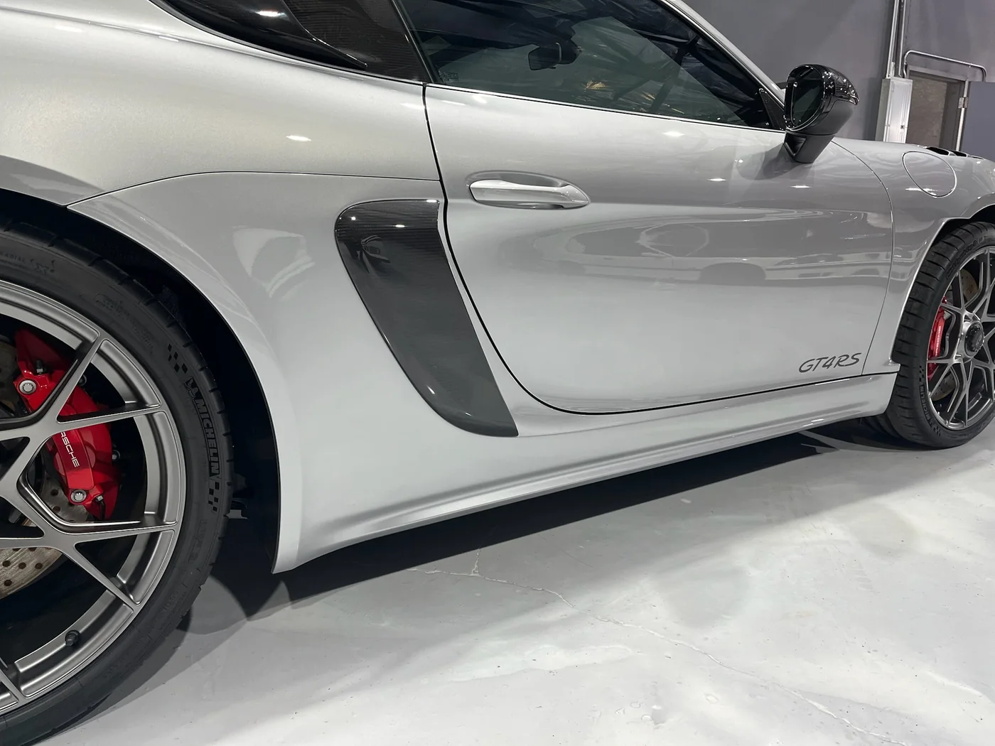 Side intake and flank of a white Porsche 718 Cayman GT4 RS after paint correction and coating