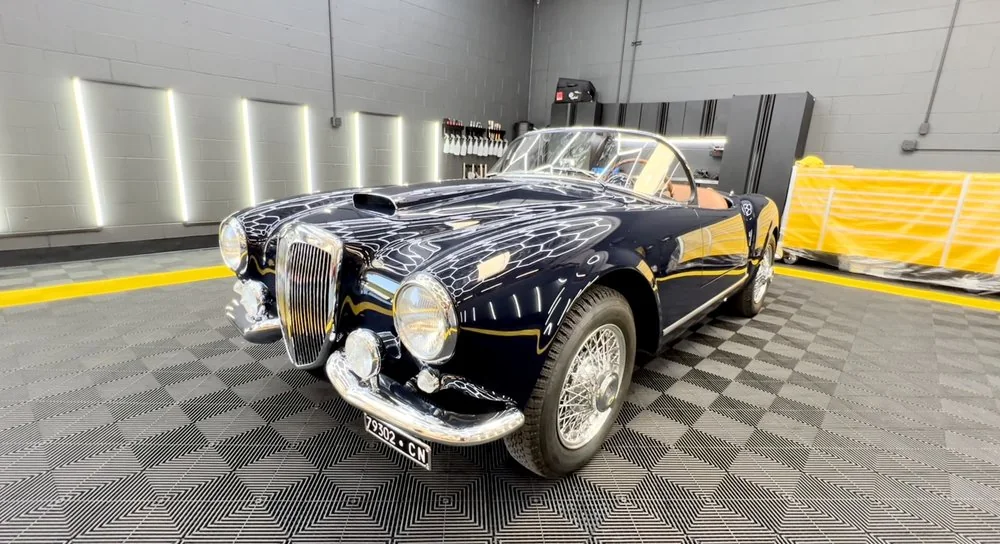Dark blue classic Alfa Romeo coupe parked on the checkered workshop floor at Artec Automotive