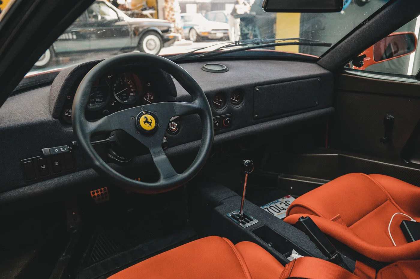 Ferrari interior with red seats and gated shifter after a full interior detail at Artec Automotive