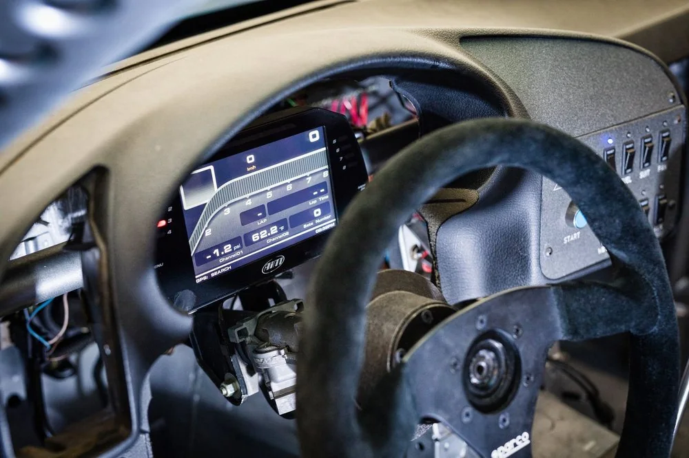 Carbon fiber steering wheel and digital dashboard display in a modern performance car