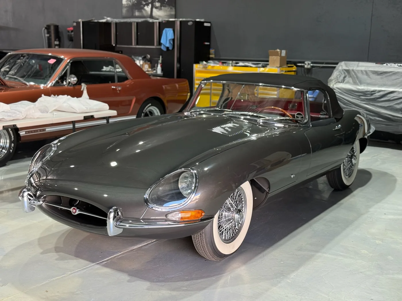 Grey Jaguar E-Type with wire wheels and whitewall tyres in the Artec workshop