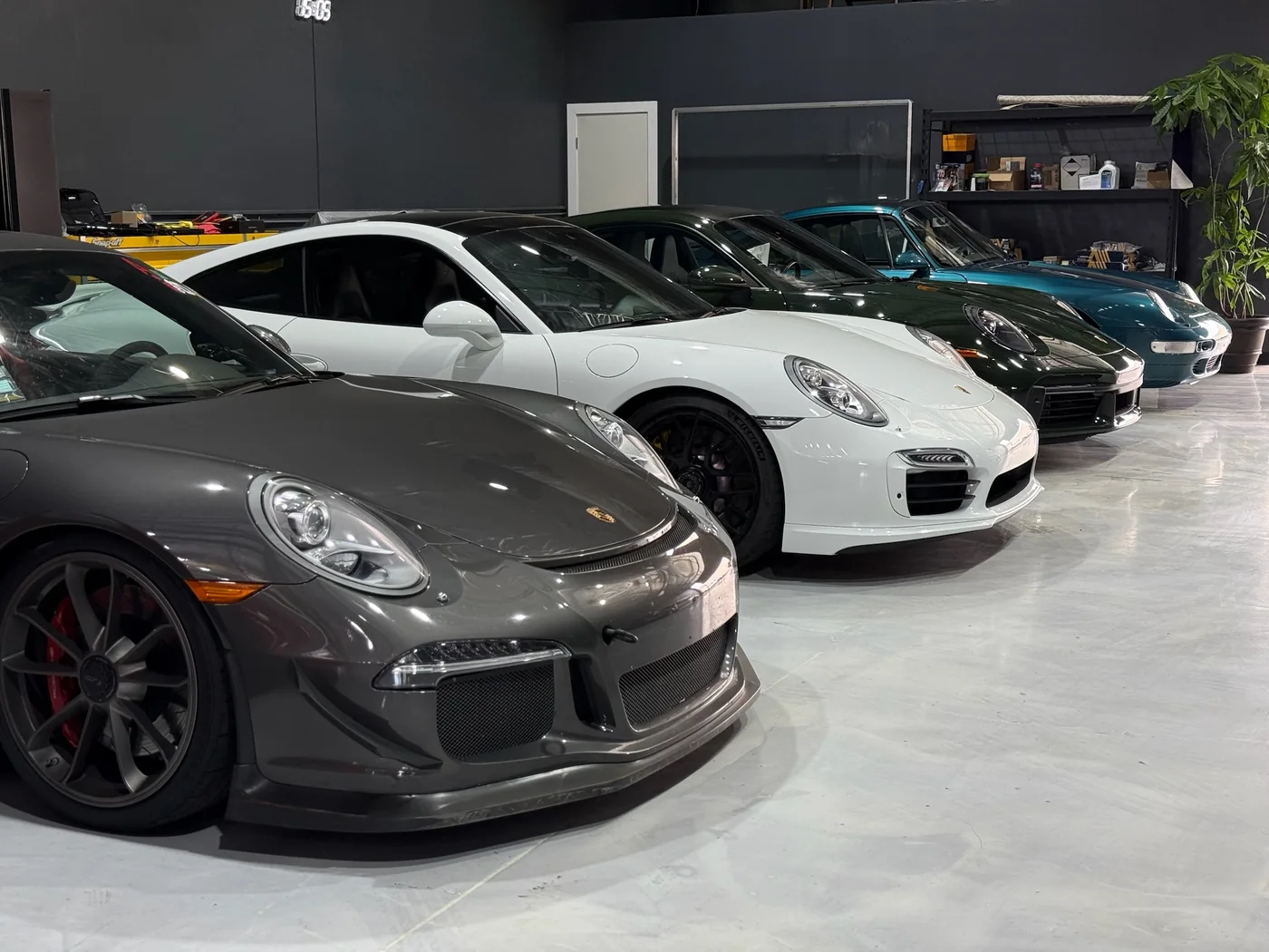 Grey Porsche 911 GT3 parked with other 911s in the Artec Automotive workshop