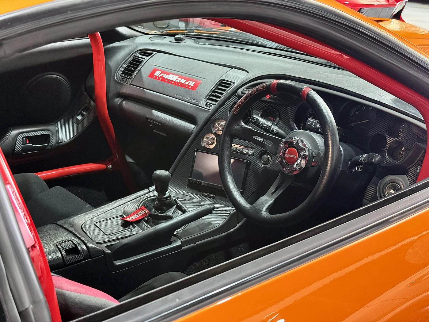 Stripped Toyota Supra interior with a racing steering wheel and roll cage