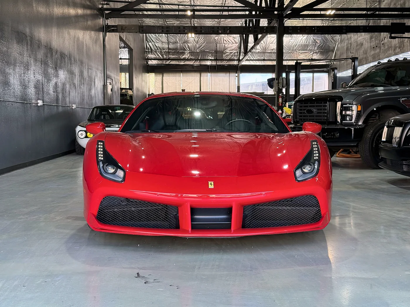 Front view of a red Ferrari 488 in the Artec Automotive shop