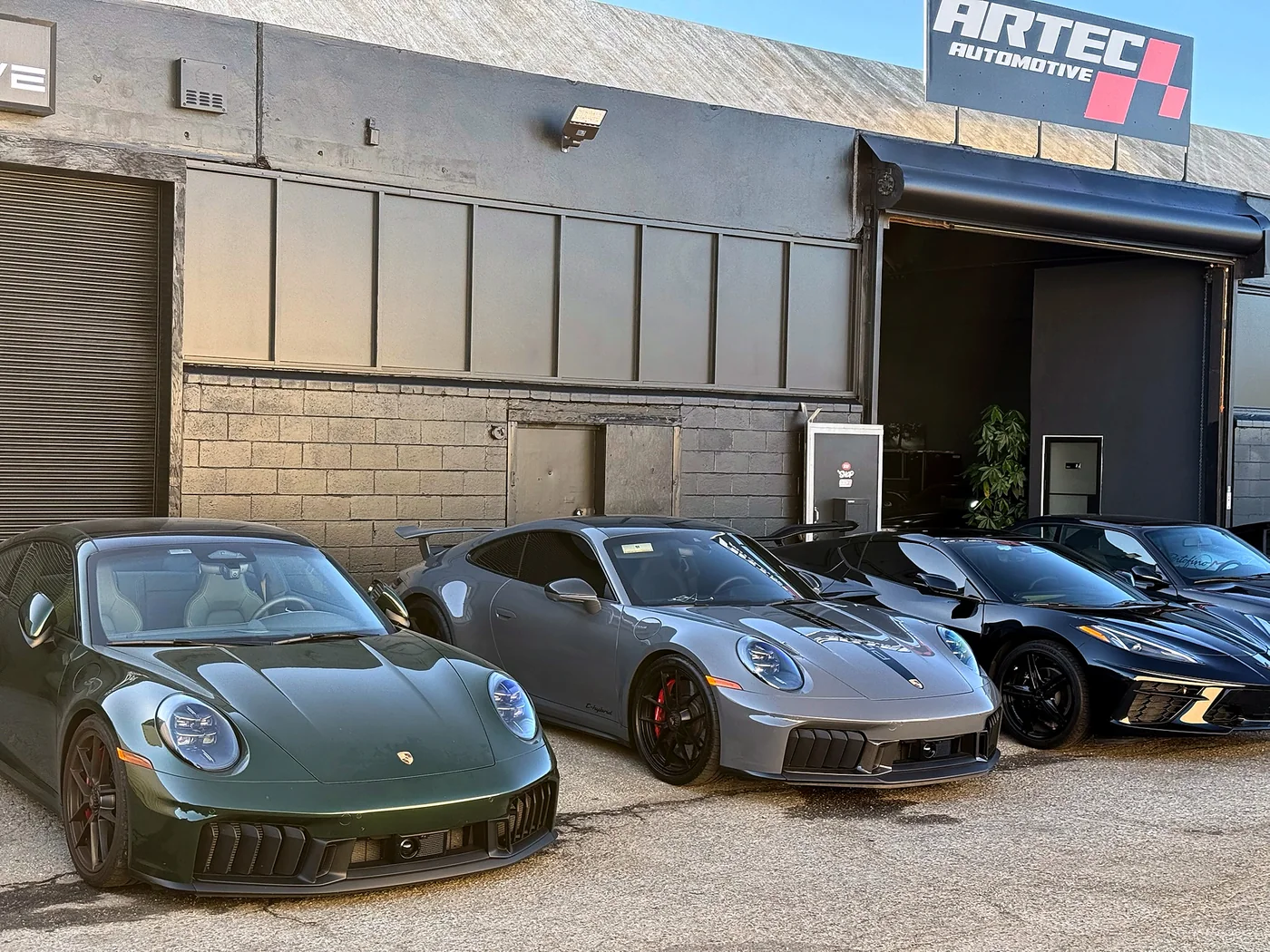 Line of Porsche 911s parked outside the Artec Automotive building in Belmont, CA