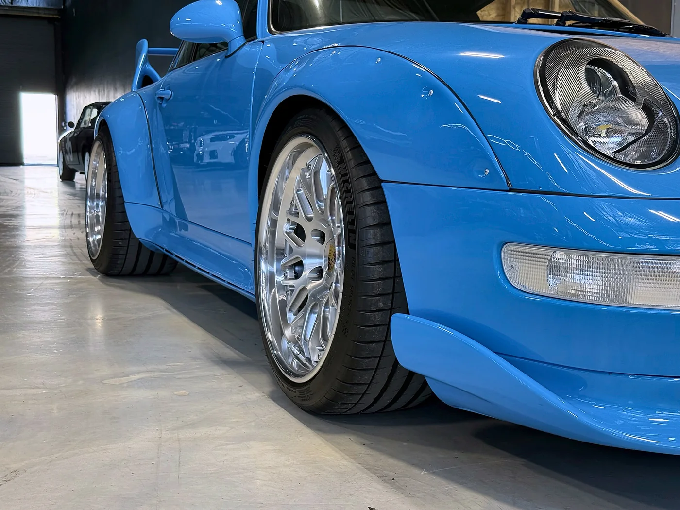 Front wing and split-rim wheel detail of a Riviera Blue Porsche 993 RS