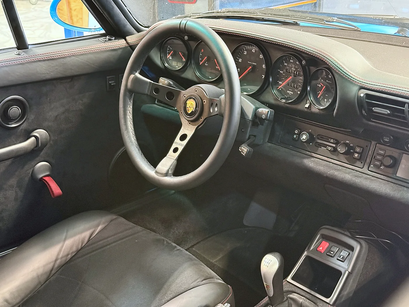 Classic Porsche interior with wood-rimmed steering wheel and period gauges