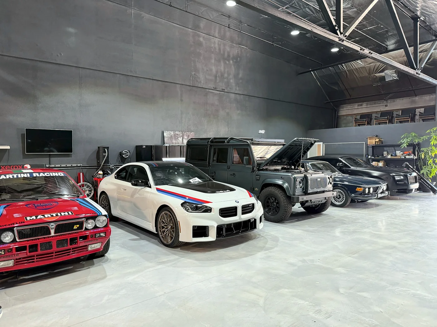 White BMW M car with Martini livery alongside other builds in the Artec Automotive shop