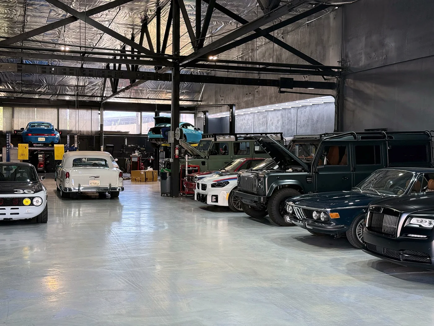 Classic BMW and Mercedes saloons parked inside the Artec Automotive workshop