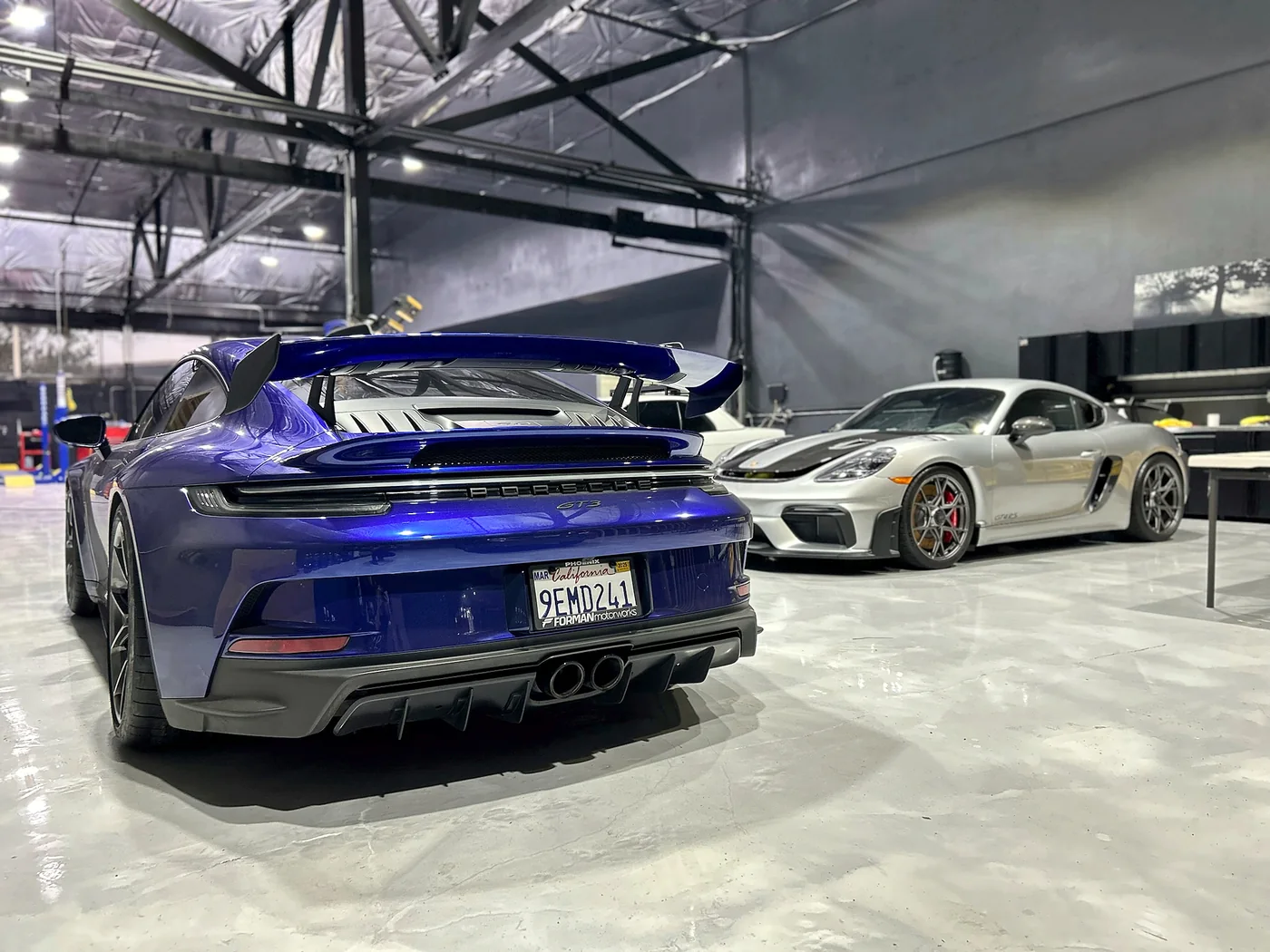Purple Porsche 911 GT3 alongside other Porsches in the Artec Automotive shop