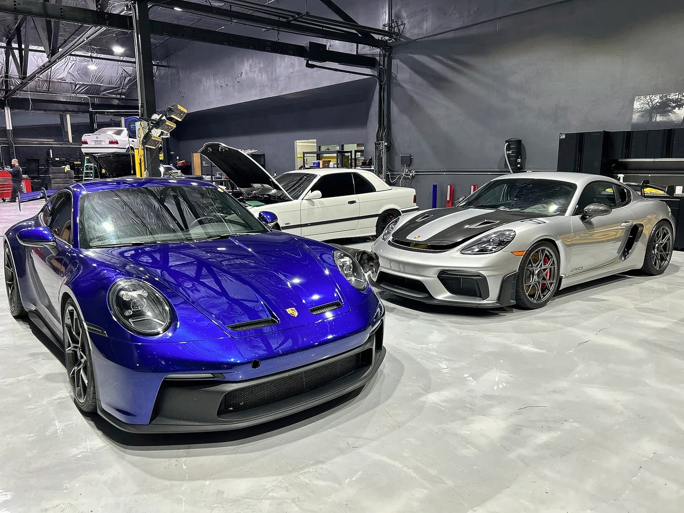 Purple Porsche 911 GT3 with other 911s lined up behind at Artec Automotive