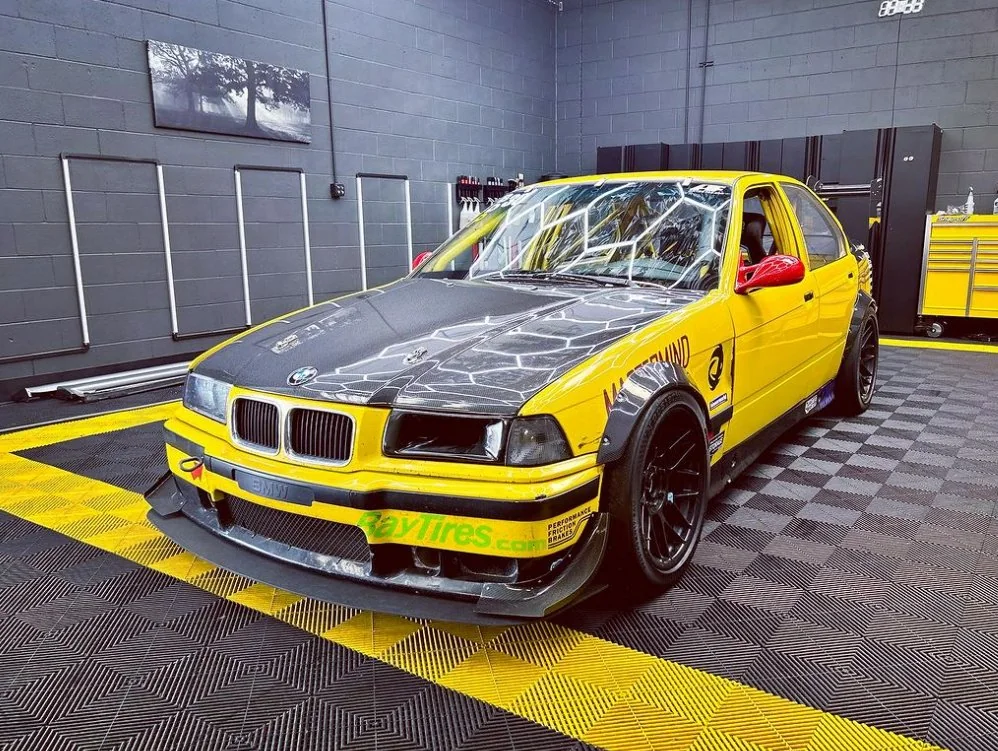 Front view of a yellow BMW E36 track car built and maintained at Artec Automotive