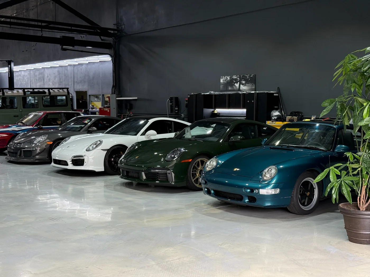 Row of classic and modern Porsche 911s parked together at Artec Automotive