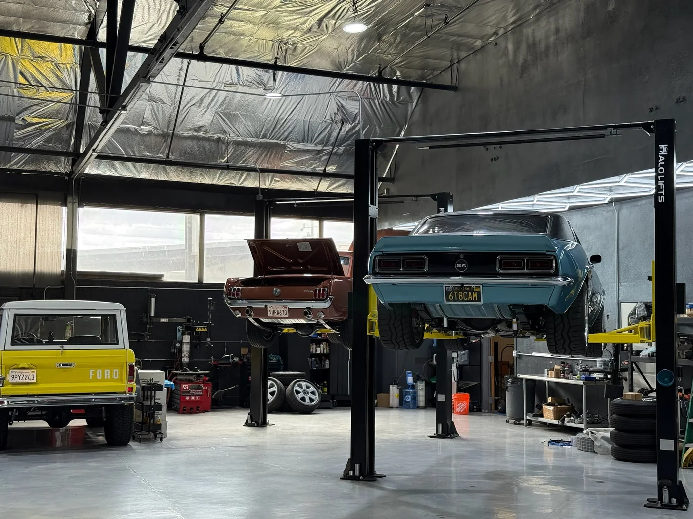 Classic race car raised on a two-post lift in the Artec workshop