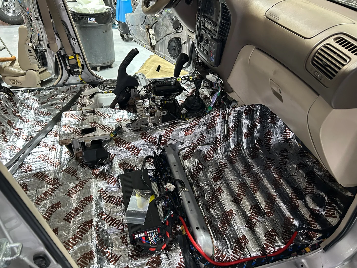 Sound deadening material being fitted to a stripped vehicle floor
