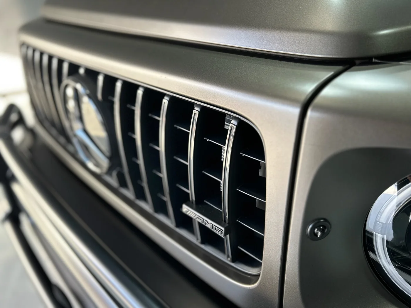 Close-up of the front grille on a matte green Mercedes-AMG G63