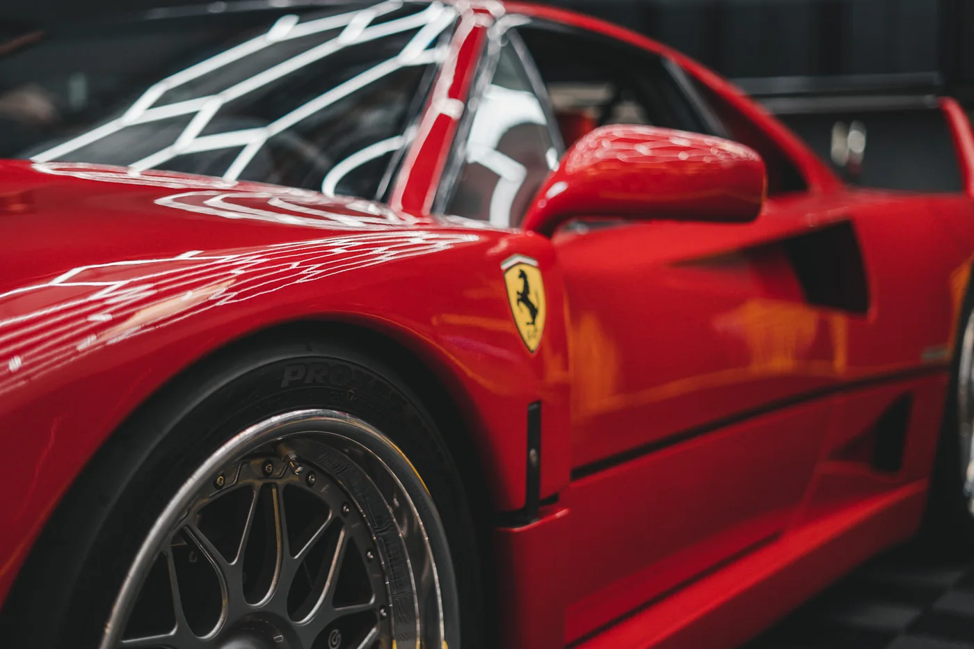 Front three-quarter view of a red Ferrari F40 in the Belmont workshop