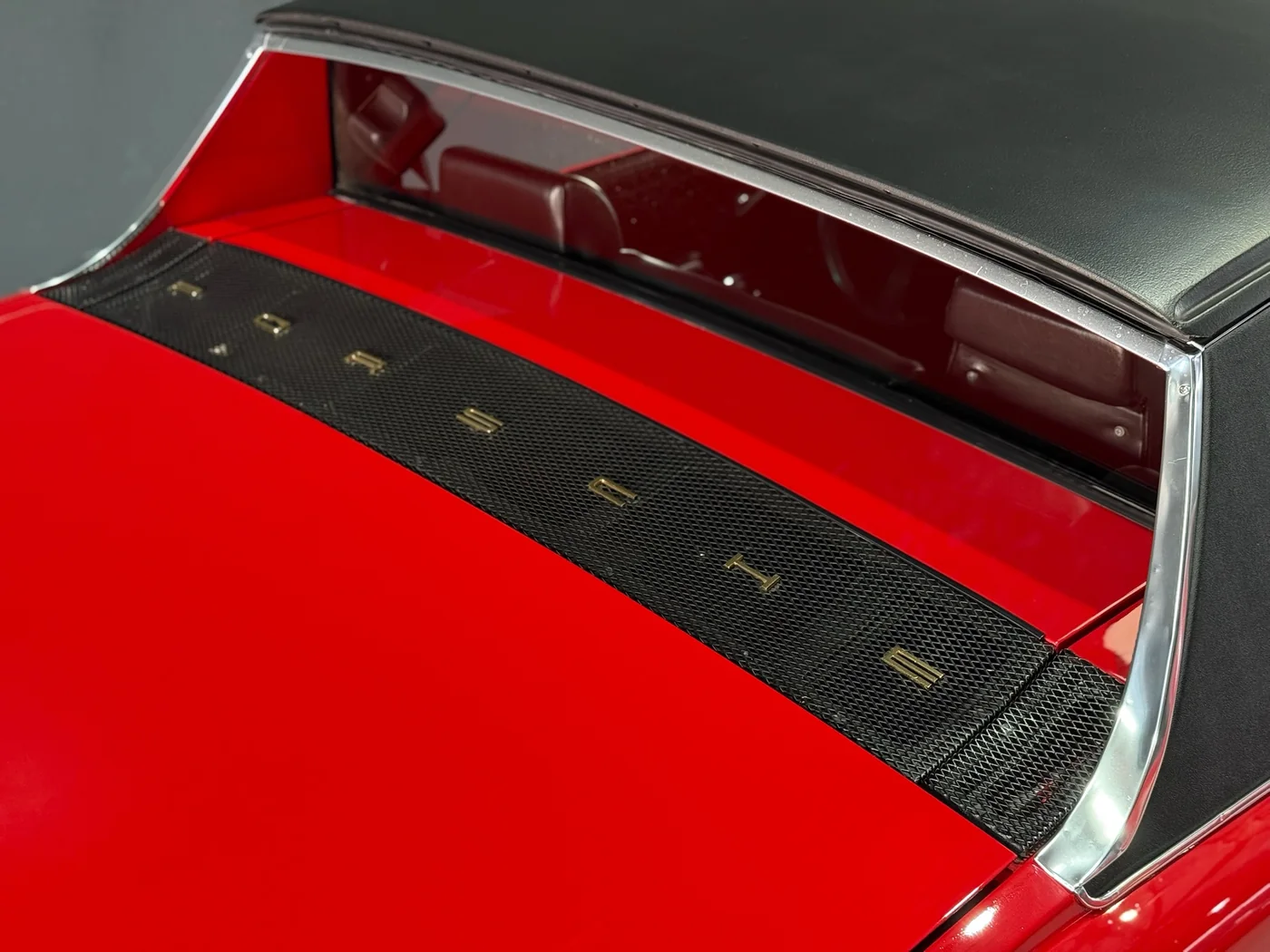 Roof and window trim detail of a red classic car after paint correction