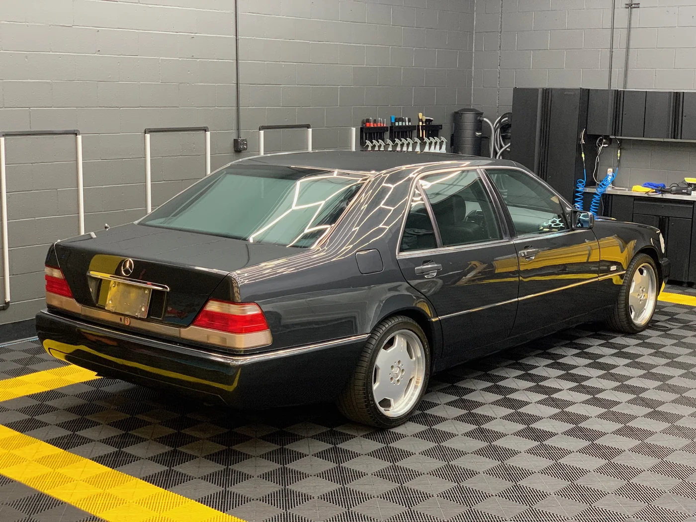 Classic Mercedes-Benz W124 saloon on the checkered workshop floor