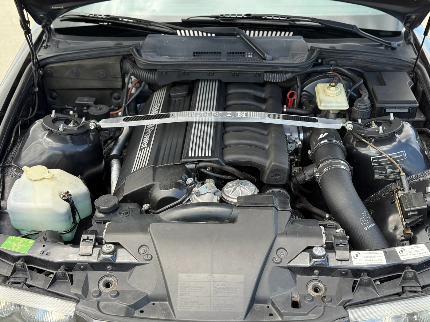 Engine bay of a BMW inline-six during service at Artec Automotive
