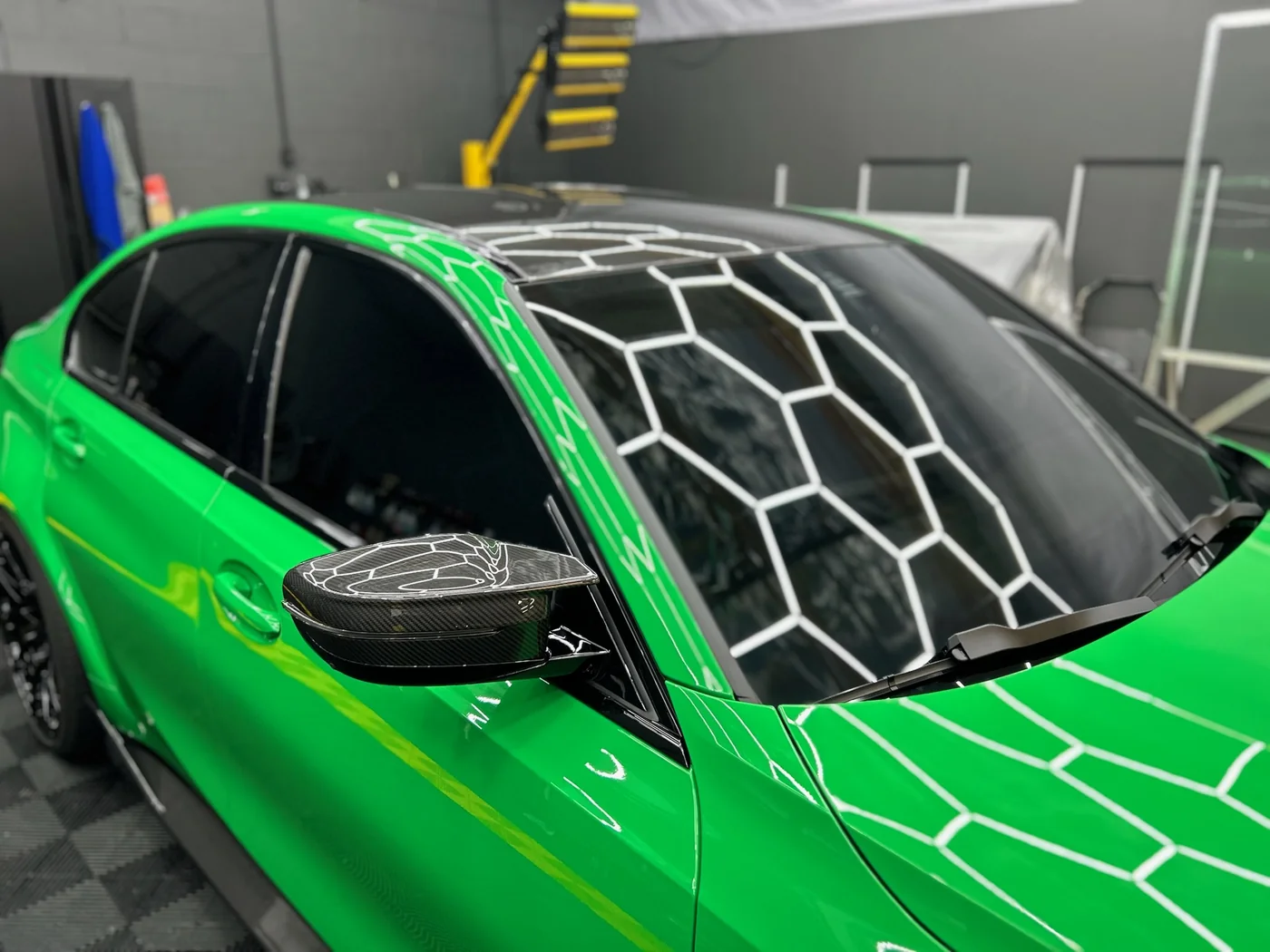 Green sports car bonnet during ceramic coating application