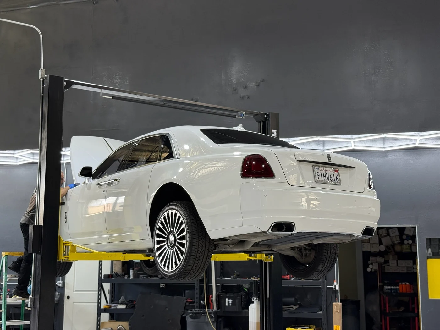 White Rolls-Royce Ghost raised on a two-post lift for service at Artec Automotive in Belmont, CA